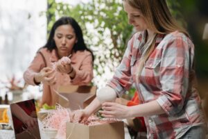 Two people packing products into cardboard boxes at a worktable